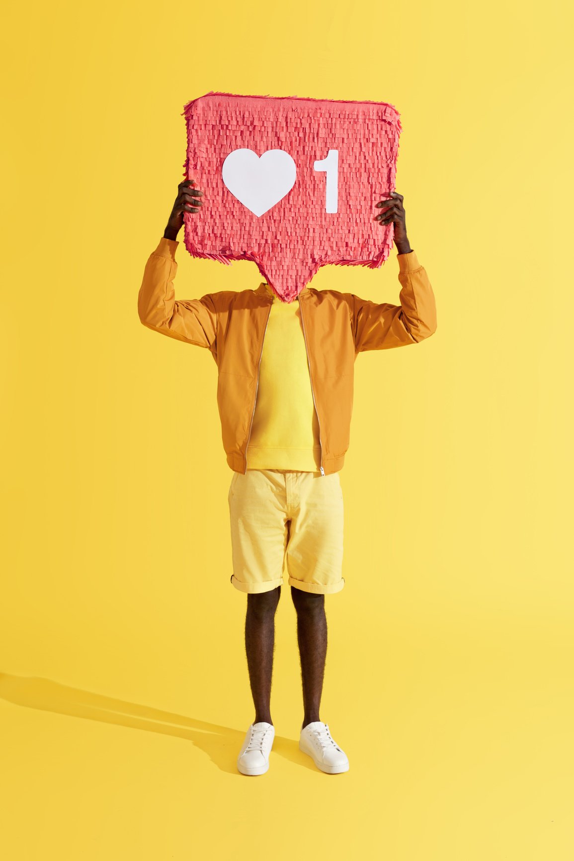 Like. Man holding social media like icon on yellow background